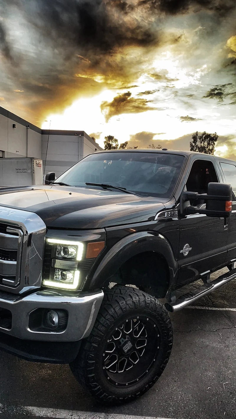 Black pickup truck with large wheels on a cloudy sky background
