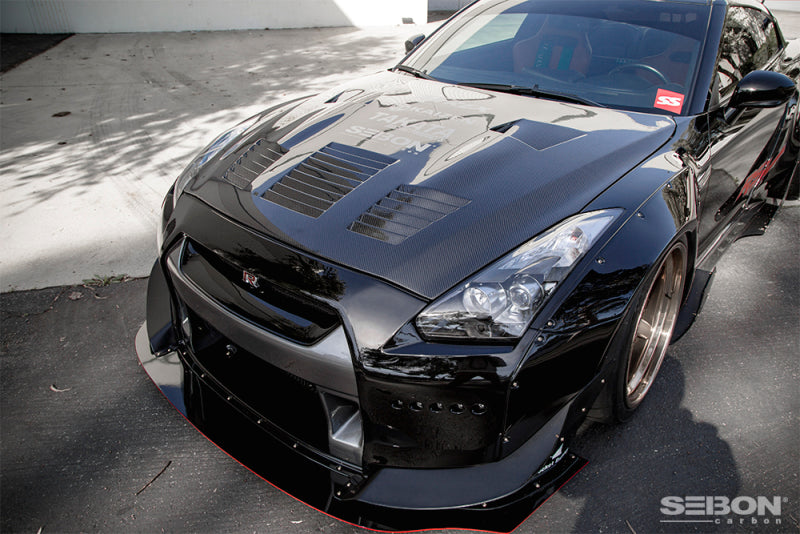 Angled side profile of a Nissan GT-R with the Seibon HD0910NSGTR-GT hood, emphasizing its aerodynamic enhancements and lightweight construction.