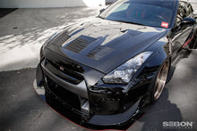 Load image into Gallery viewer, Angled side profile of a Nissan GT-R with the Seibon HD0910NSGTR-GT hood, emphasizing its aerodynamic enhancements and lightweight construction.