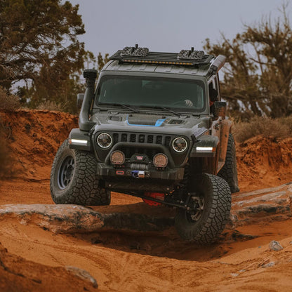 Off-road vehicle navigating a rocky dirt path in a desert landscape