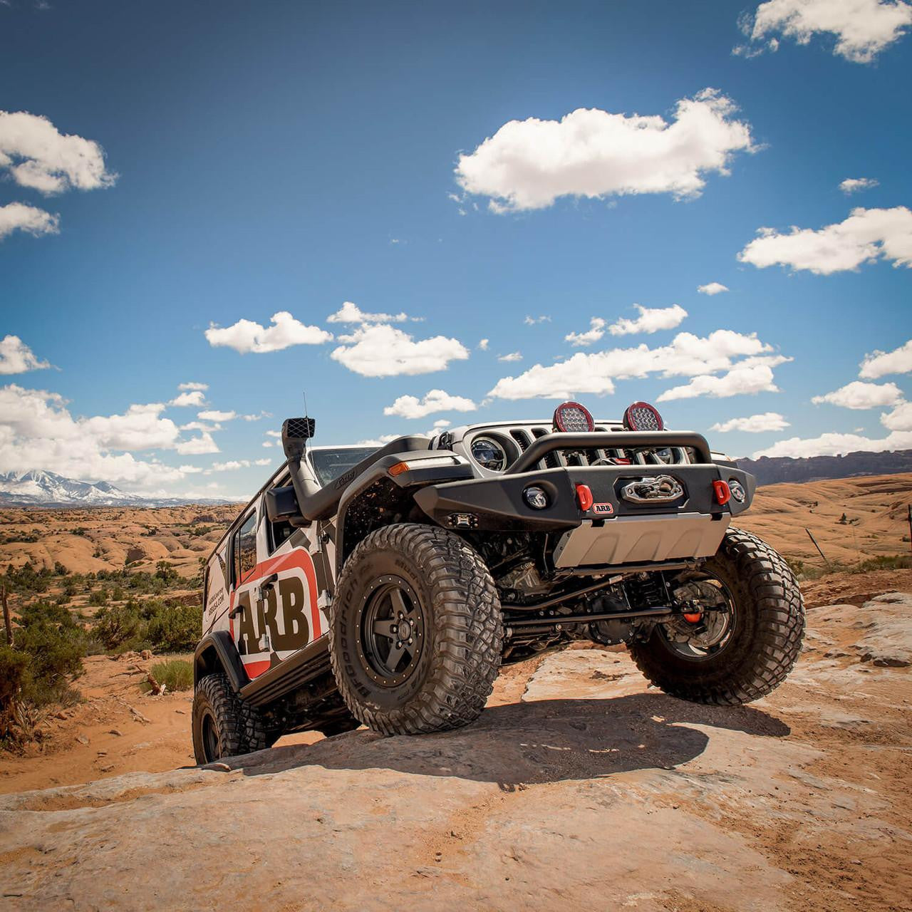 Off-road vehicle on a rocky terrain with a clear blue sky