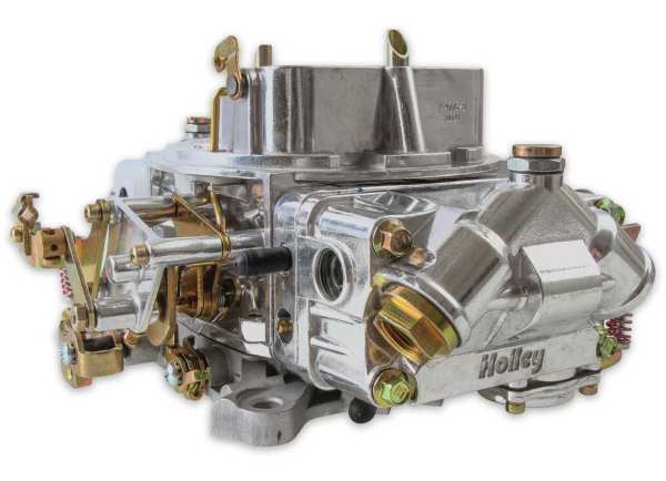 Polished Holley four-barrel carburetor with dual fuel bowls and mechanical throttle linkage.