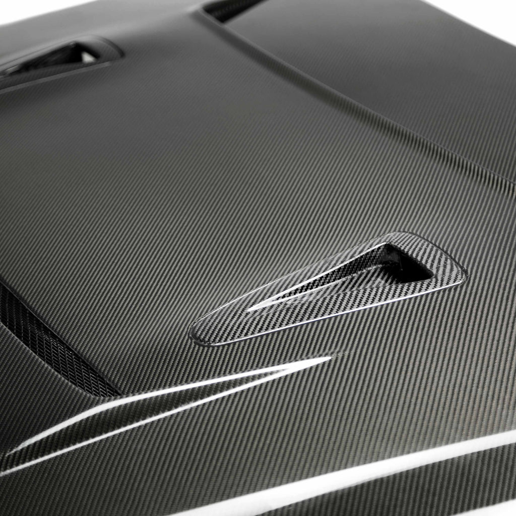 Angled shot of the Seibon HD0910NSGTR-DV DV-Style Carbon Fiber Hood, installed on a GT-R, highlighting the seamless integration with the vehicle's sporty design.