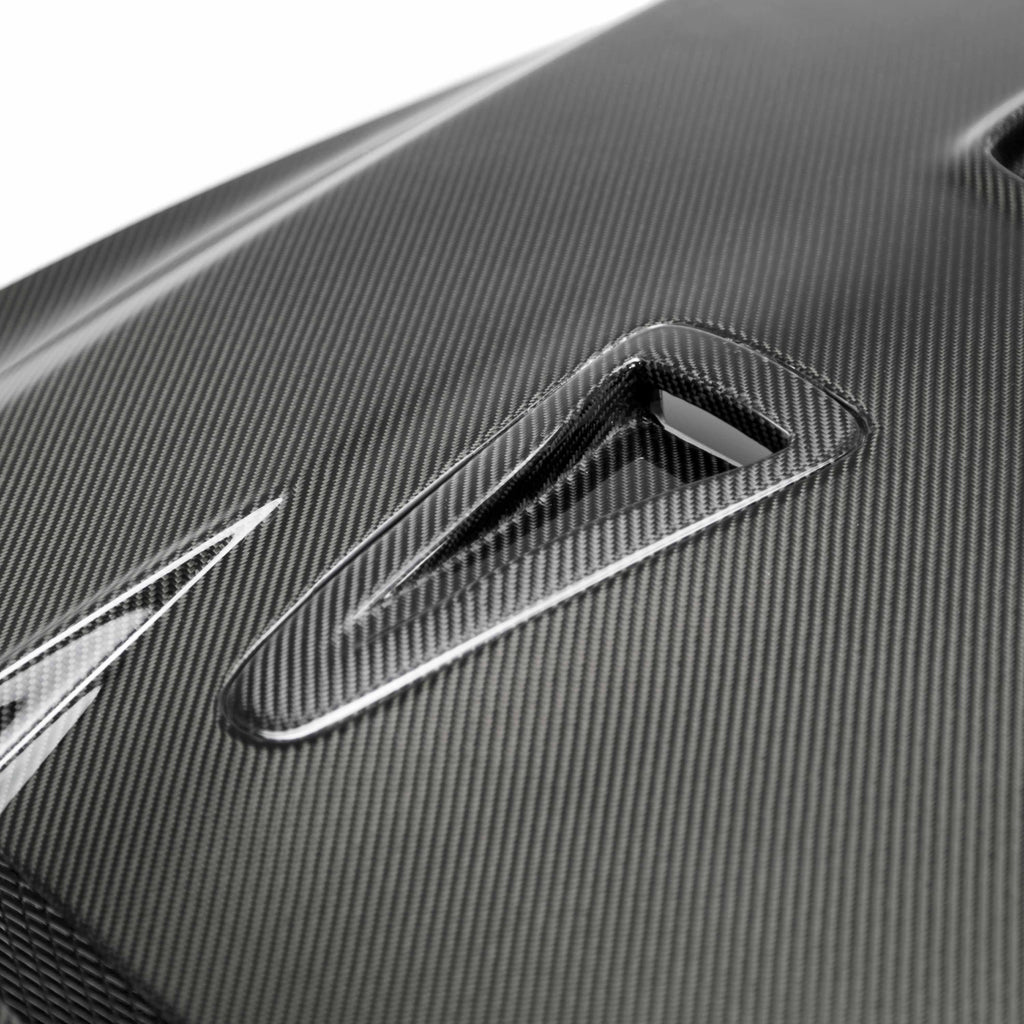 Detailed shot of the Seibon DV-Style Carbon Fiber Hood's carbon fiber texture, showcasing its lightweight construction and premium craftsmanship.