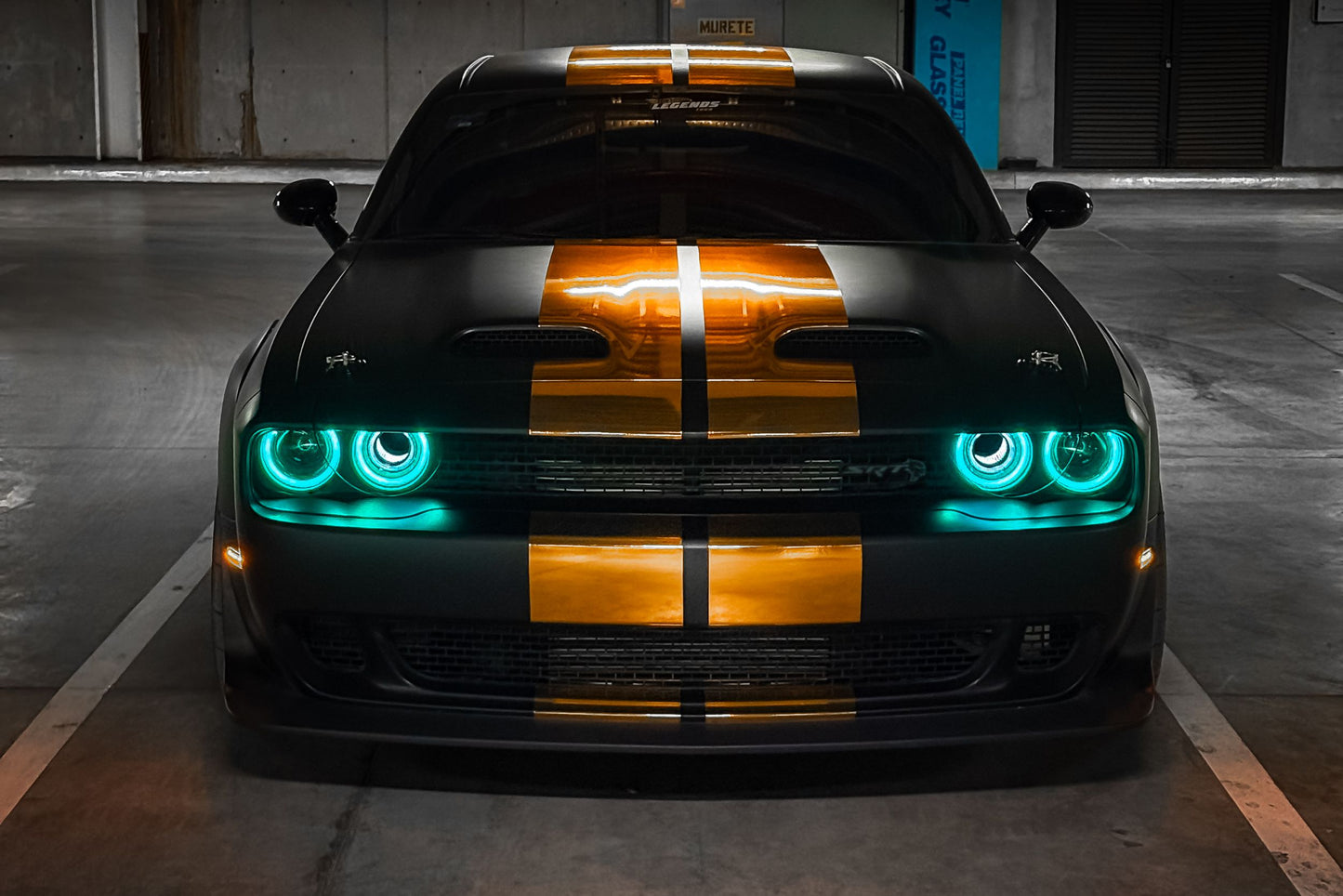 Close-up of Morimoto XRGB LF495 LED headlights illuminated on Dodge Challenger