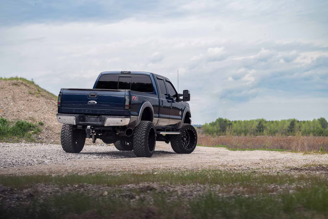 Blue pickup truck on a gravel road with a clear sky