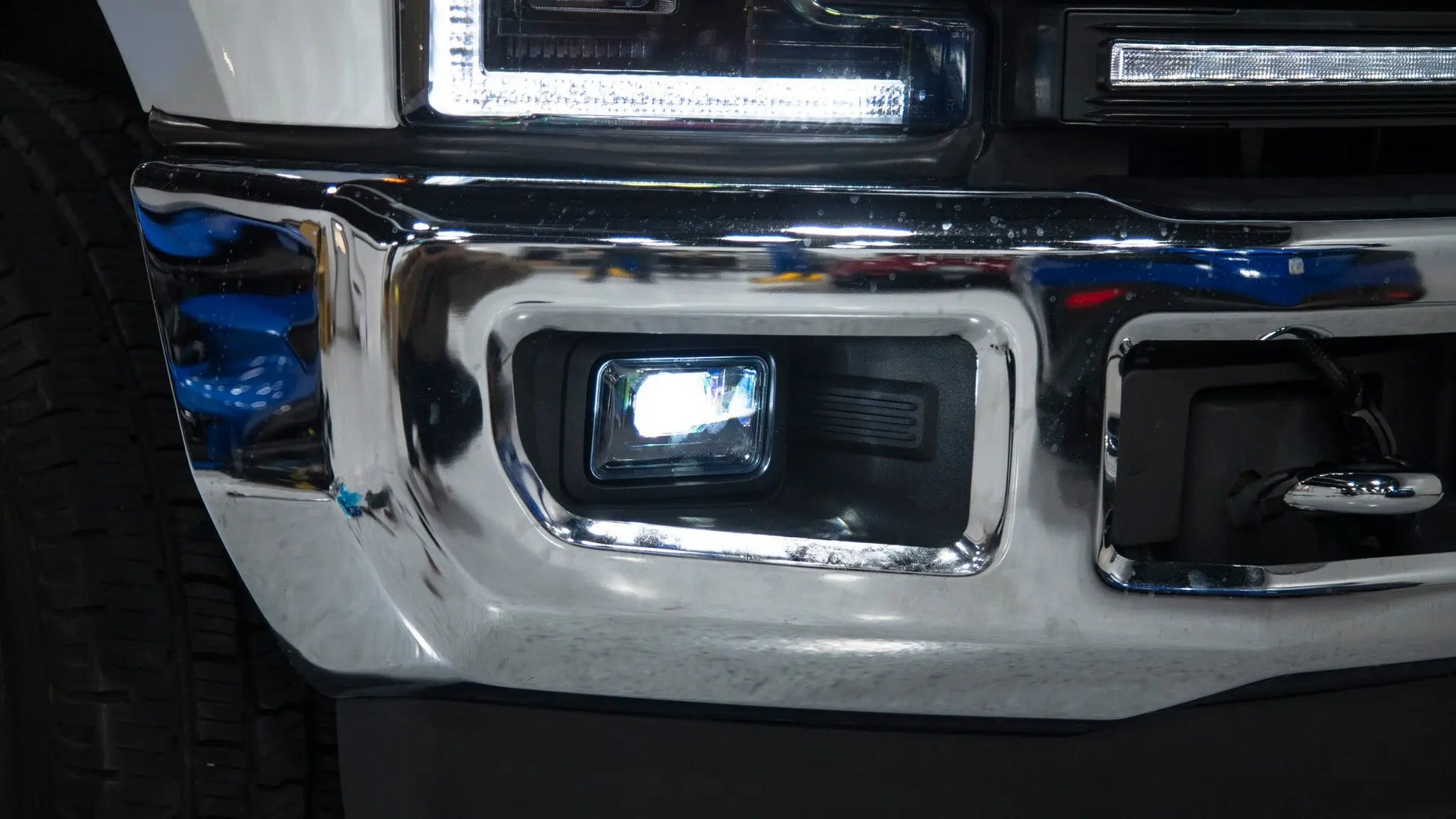 Close-up of a vehicle's chrome bumper and headlight