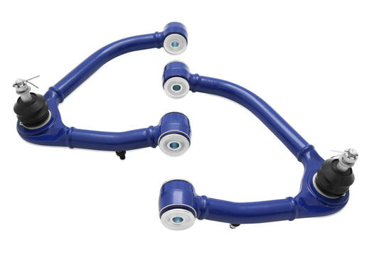 SuperPro TRC6655 fixed‑offset upper control arms installed on a lifted Chevrolet Silverado 1500 front suspension.